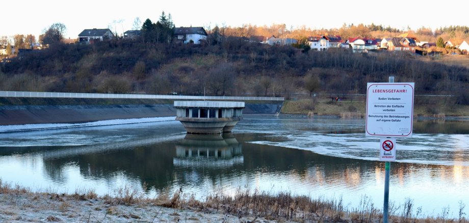 Eiswarnung Aartalsperre Blick auf den Hauptdamm mit Bischoffen im Hintergrund und Eis auf der Wasserfläche