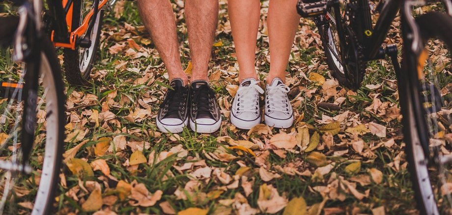 Die Beine zweier Menschen zwischen zwei Fahrrädern