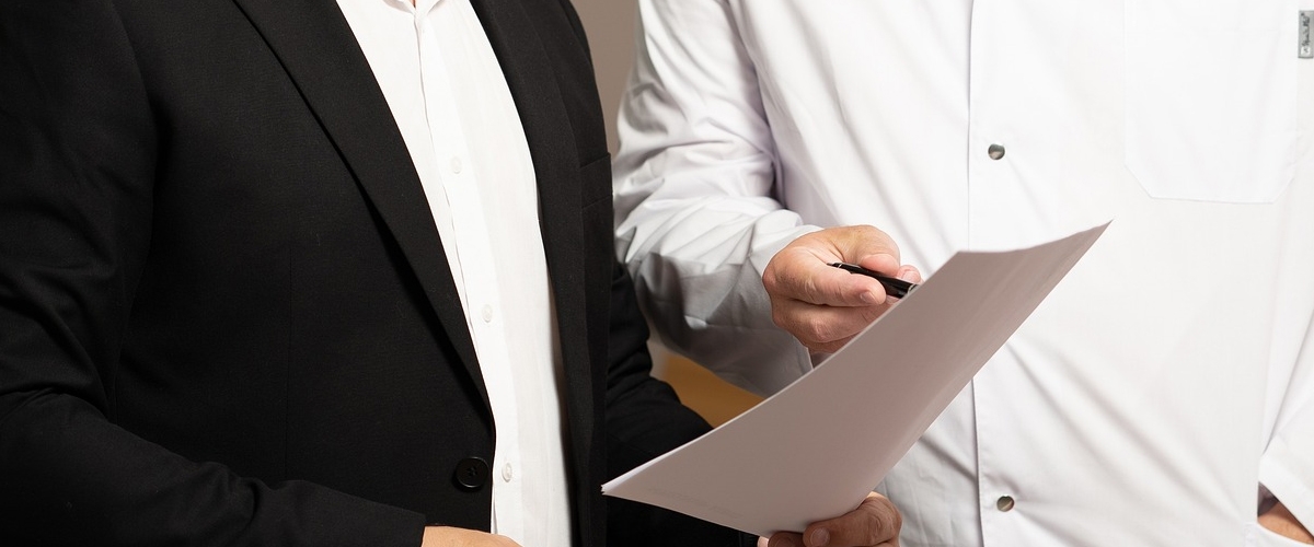 Ein Mann zeigt einem anderen Mann etwas auf einem Blatt Papier