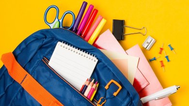 Rucksack aus dem Schulutensilien herausschauen