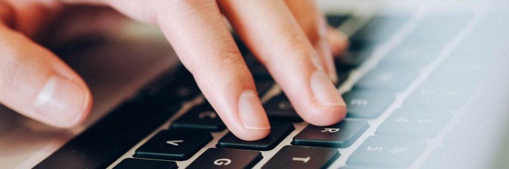 Finger die auf einer Laptoptastatur tippen