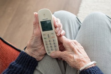 Seniorenberatung Seniorin hält Telefon in der Hand