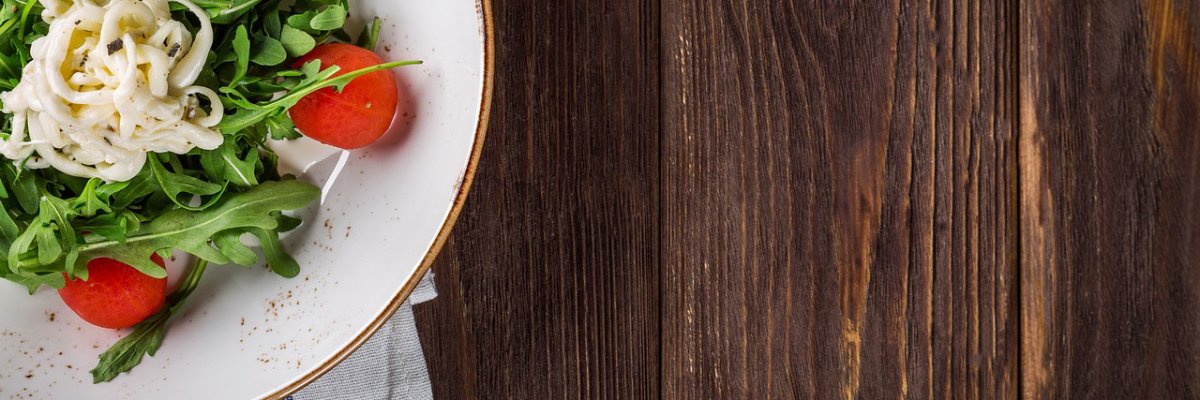 Ein Teller mit Salat auf einem Holztisch